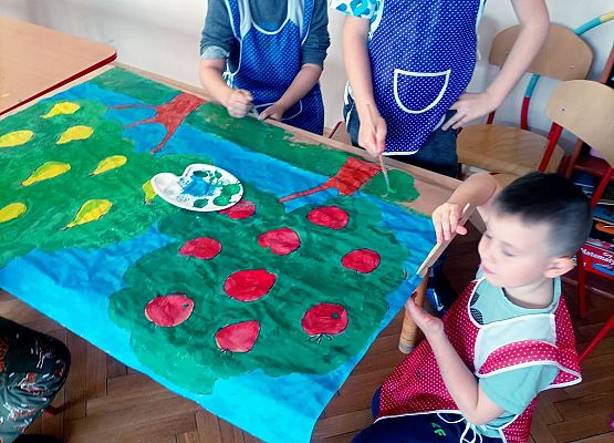 Chłopcy wykonują plakat do szkolnego sadu