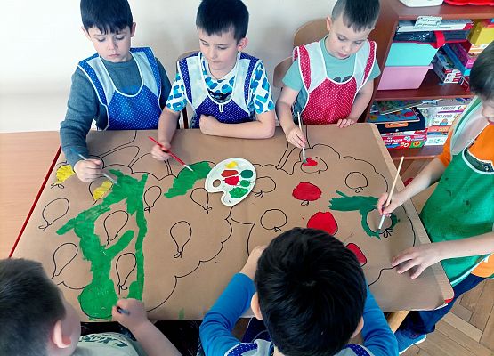 Chłopcy wykonują plakat do szkolnego sadu