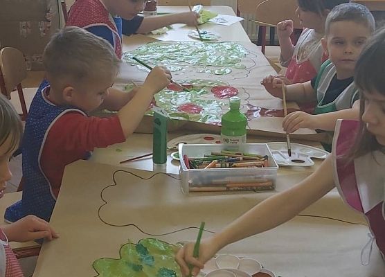 Dzieci malują drzewa na plakacie