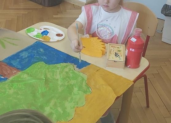 Dziewczynka maluje farbami plakat