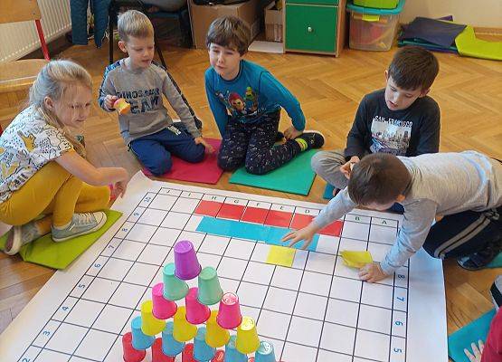 Dzieci kodują na macie sudoku z wykorzystaniem kolorowych kubków
