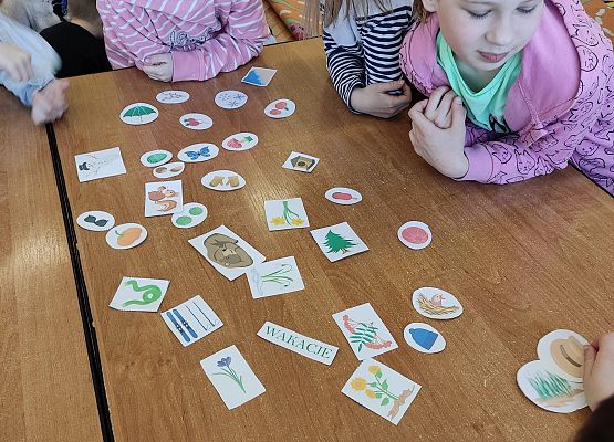Dzieci pracują w grupie i układają obrazki tworząc zbiory