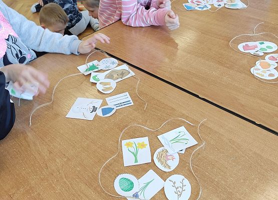 Dzieci pracują w grupie i układają obrazki tworząc zbiory