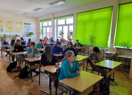 Uczniowie siedzą w ławkach