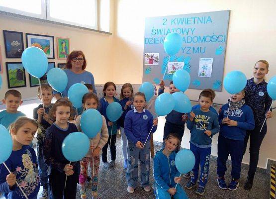 Zdjęcie grupowe dzieci i nauczycielek, wszyscy stoją i trzymają niebieskie balony