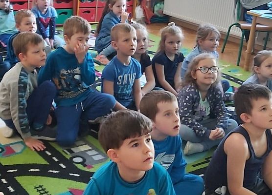 Przedszkolaki siedzą na dywanie