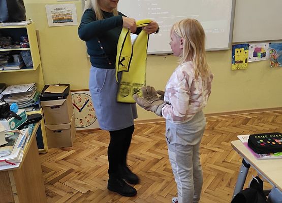 Nauczycielka zakłada dziewczynce opaskę na oczy