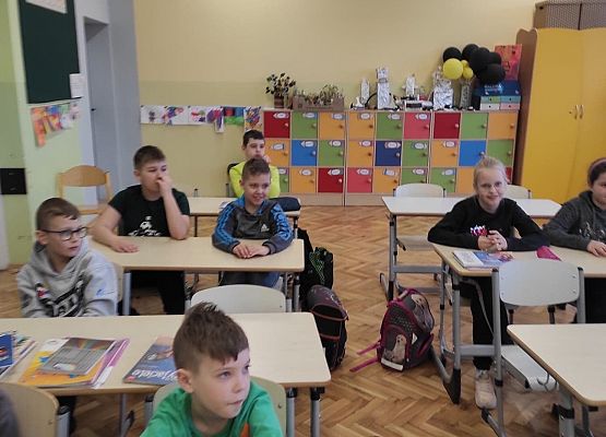 Uczniowie siedzą w ławkach