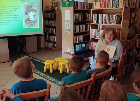 Nauczycielka prowadzi zajęcia w bibliotece.