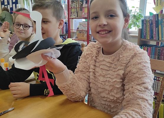 Uczennice prezentują papierowe bociany