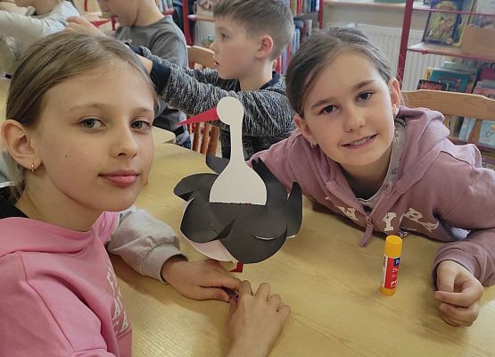 Uczennice prezentują papierowe bociany
