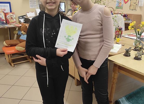 Uczennice prezentują papierowe obrazek, króry wykonały