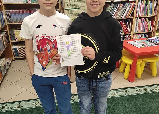 Dwaj chłopcy prezentują wykonany wiosenny obrazek