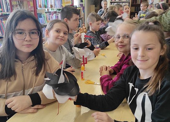 Uczennice prezentują papierowe bociany