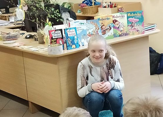 Uczennica kuca przy biurku