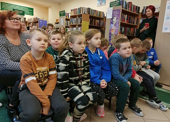 Uczniowie siedzą w bibliotece