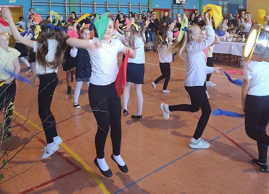 Uczniowie tańczą z kolorowymi chustami