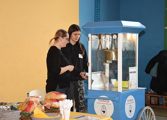 Nauczycielka i uczennica stoją przy maszynie do popcornu