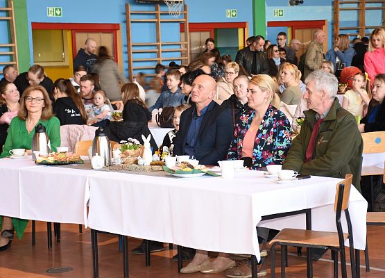 Przy stole siedzą uczestnicy kiermaszu