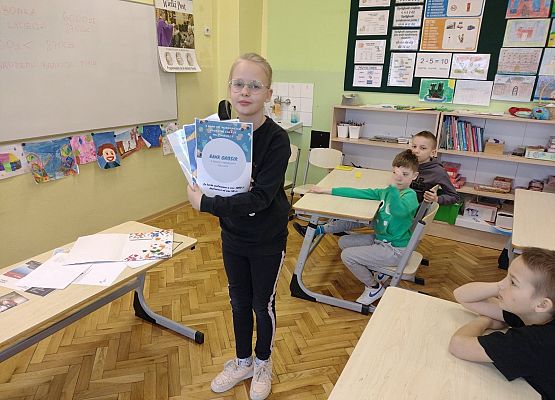 Uczennica pokazuje reklamę banku