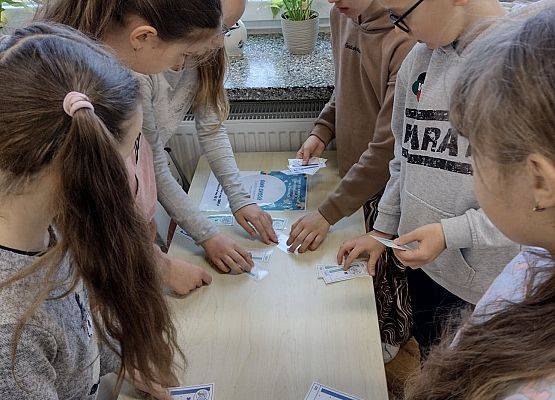 Uczniowie liczą zabawkowe pieniądze