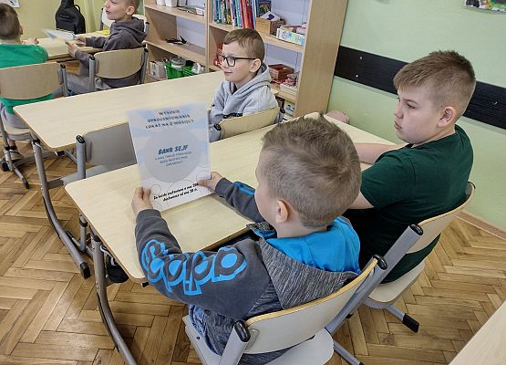 Uczniowie oglądają reklamę banku