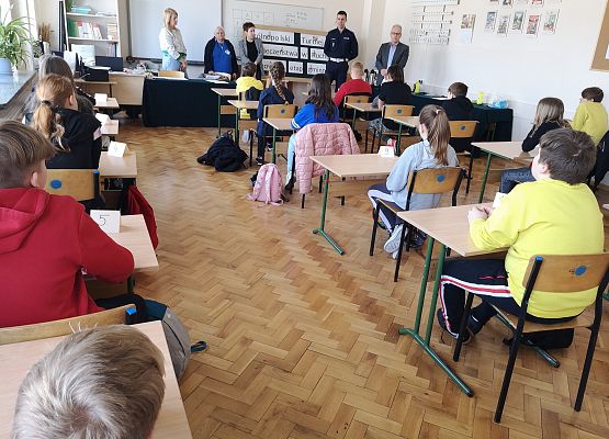 Uczestnicy turnieju siedzą przy stolikach