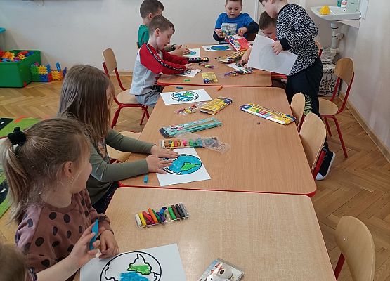 Dzieci wyklejają plasteliną rysunek planety Ziemia