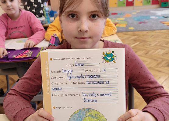 Uczennica prezentuje  życzenia dla Ziemi