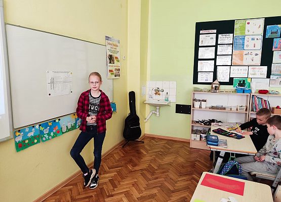 Uczennica rozwiązuje na tablicy krzyżówkę