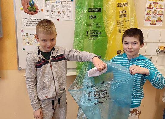 Uczniowie trzymają worek do segregacji śmieci