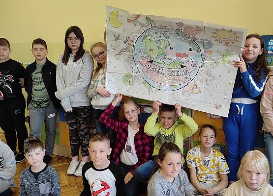 Zdjęcie grupowe dzieci z plakatem Ziemi