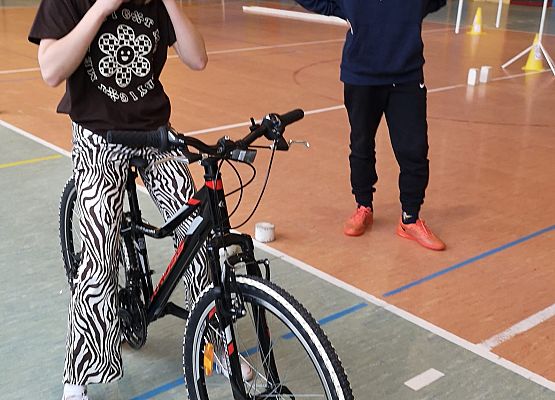 Uczennica przygotowuje się do startu i zapina kask