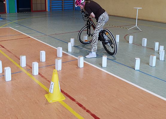 Uczennica na rowerze pokonuje tor przeszkód