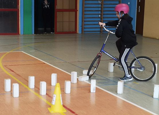 Uczennica na rowerze pokonuje tor przeszkód