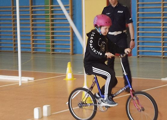 Uczennica na rowerze pokonuje tor przeszkód