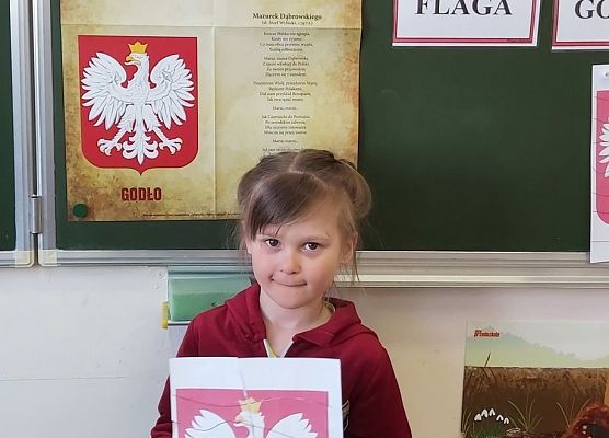 Dziewczynka trzyma w dłoniach godło