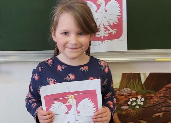 Dziewczynka prezentuje godło