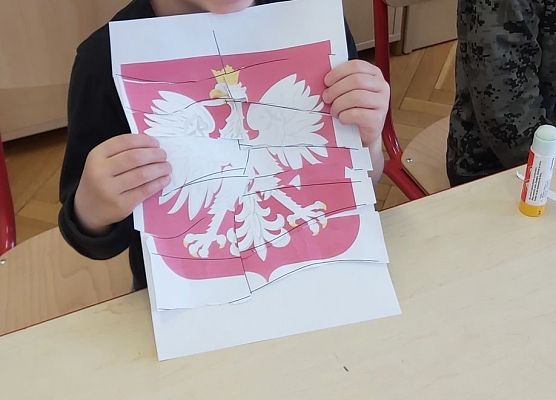 Chłopiec prezentuje godło