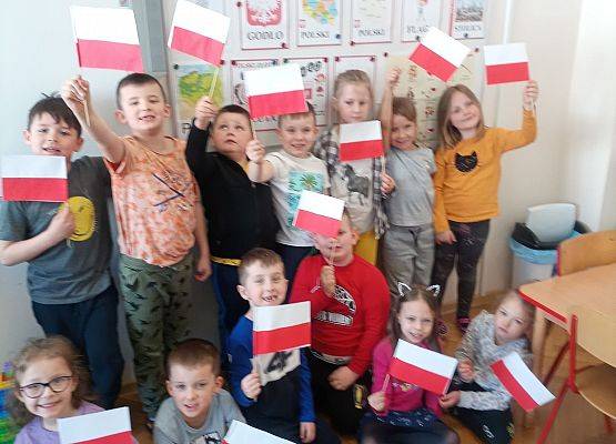 Dzieci trzymają w dłoniach flagi Polski