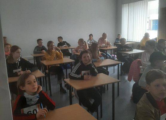 Uczestnicy turnieju siedzą przy stolikach