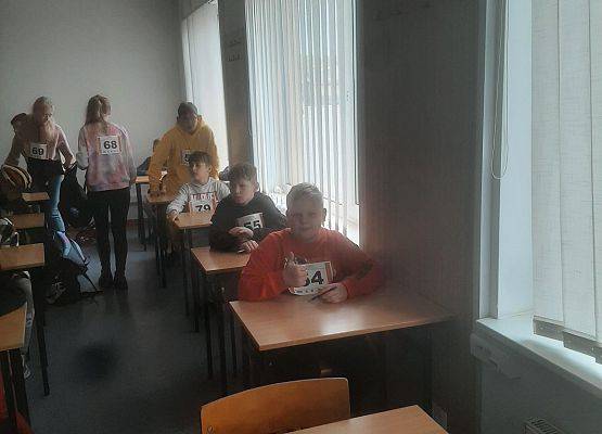 Uczestnicy turnieju siedzą przy stolikach