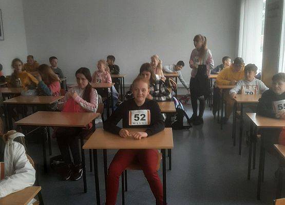 Uczestnicy turnieju siedzą przy stolikach