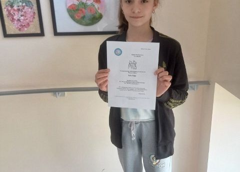 Nagrodzona uczennica prezentuje dyplom