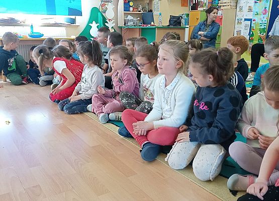 Dzieci siedzą i oglądają występ