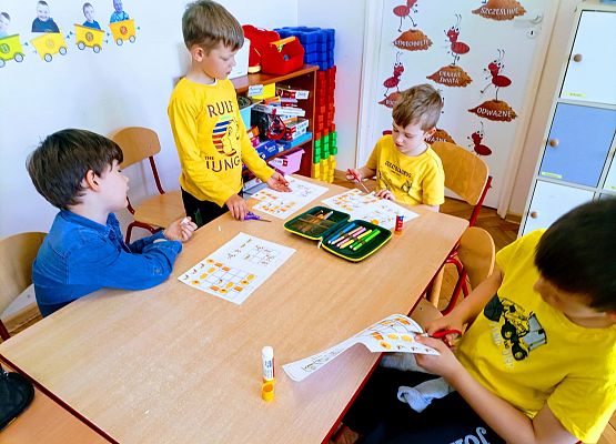 Chłopcy wycinają karty z pszczołami