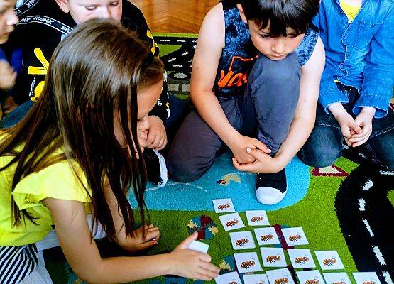 Dzieci siedzą przy ulu