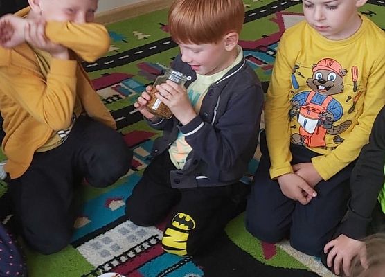 Dzieci siedzą na dywanie