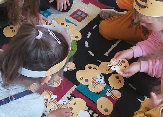 Dzieci siedzą na dywanie