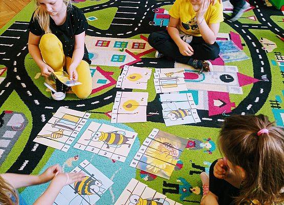 Dzieci układają puzzle o pszczołach